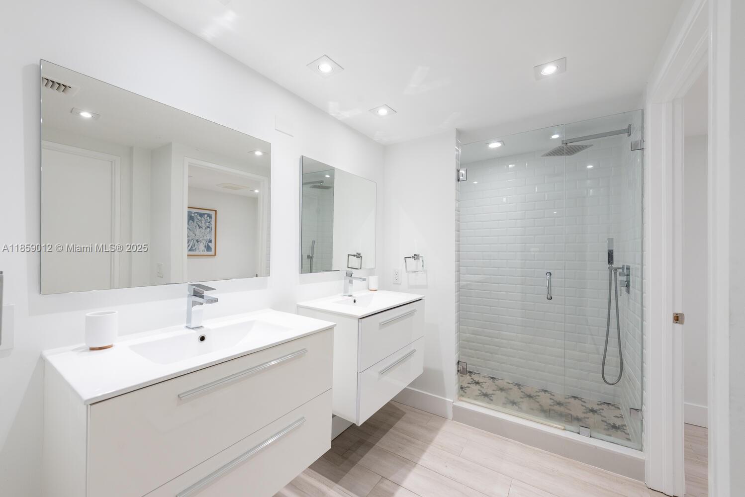 181 Crandon Boulevard, Unit 306 Key Biscayne, FL 33149 - Photo 15 of 25 a bathroom with a shower sink and mirror