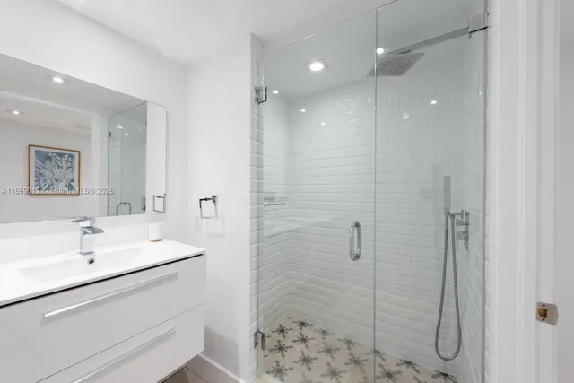a bathroom with a shower sink and mirror