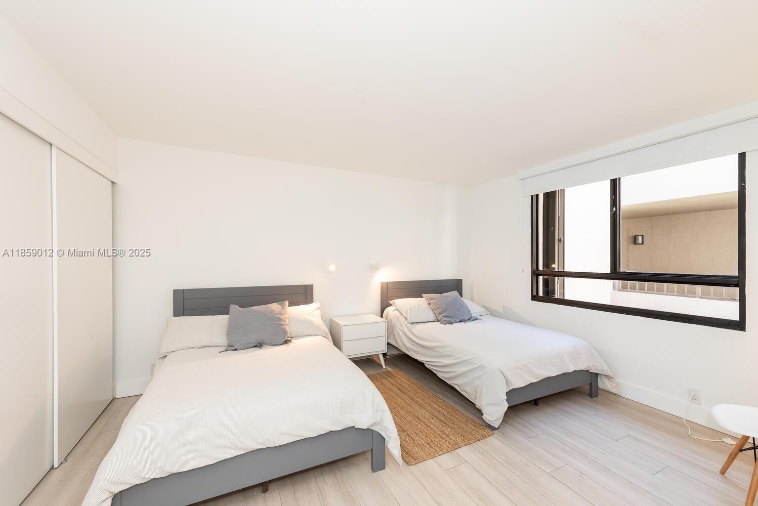 181 Crandon Boulevard, Unit 306 Key Biscayne, FL 33149 - Photo 19 of 25 a bedroom with double bed and a large window