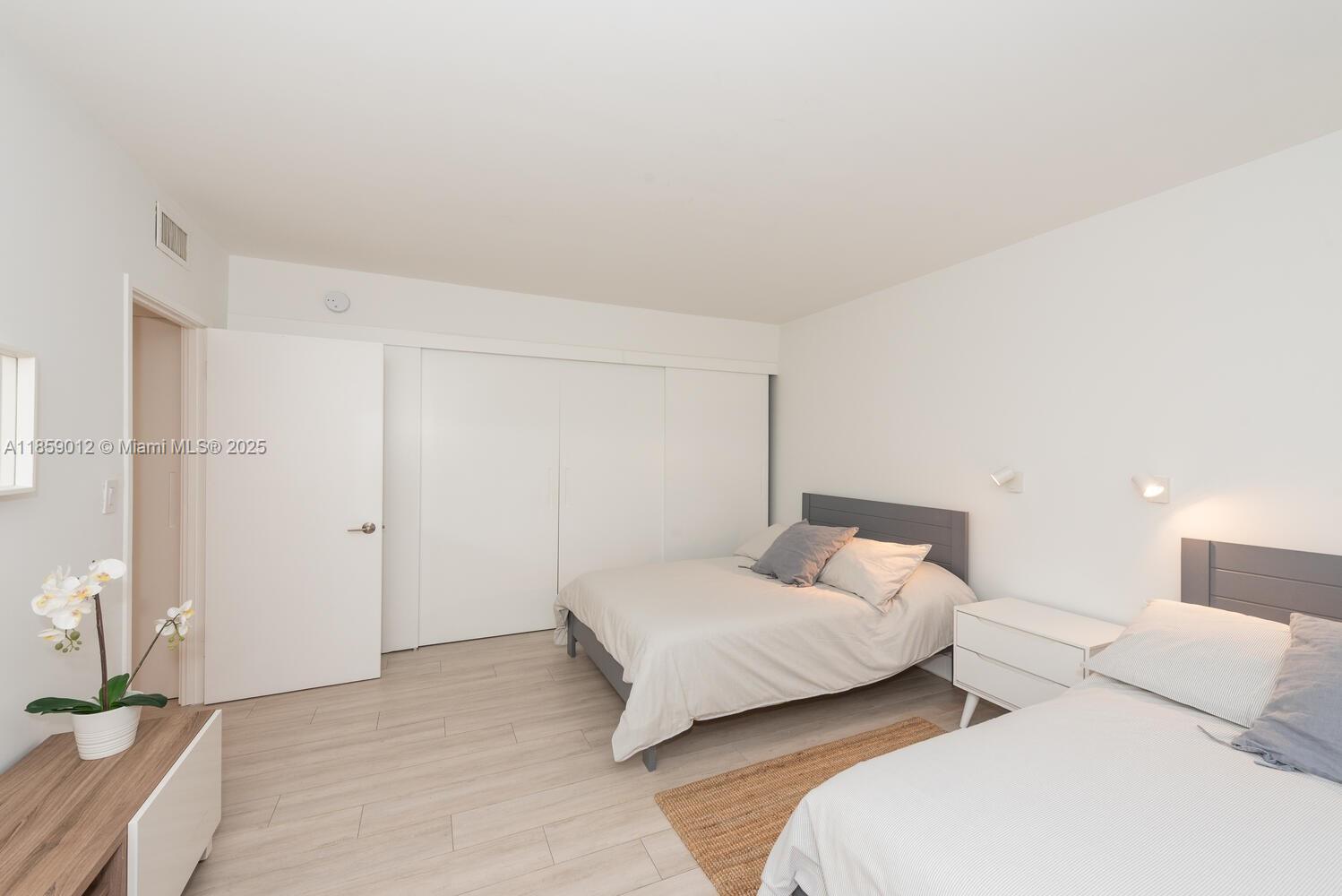 181 Crandon Boulevard, Unit 306 Key Biscayne, FL 33149 - Photo 20 of 25 a bedroom with a bed and a couch