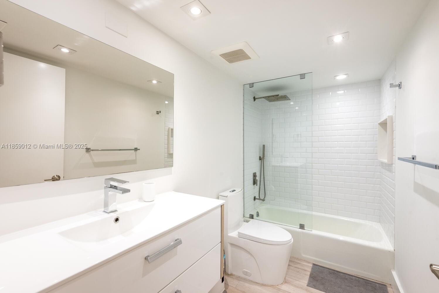 181 Crandon Boulevard, Unit 306 Key Biscayne, FL 33149 - Photo 21 of 25 a bathroom with a bathtub shower sink vanity mirror and toilet