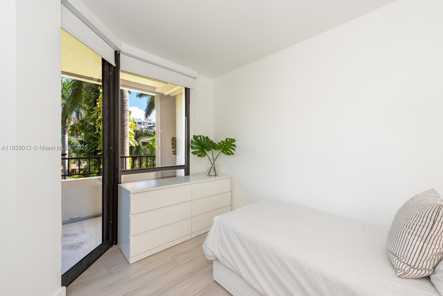 181 Crandon Boulevard, Unit 306 Key Biscayne, FL 33149 - Photo 22 of 25 a bedroom with a bed and a large window