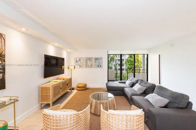 a living room with furniture a flat screen tv and a window