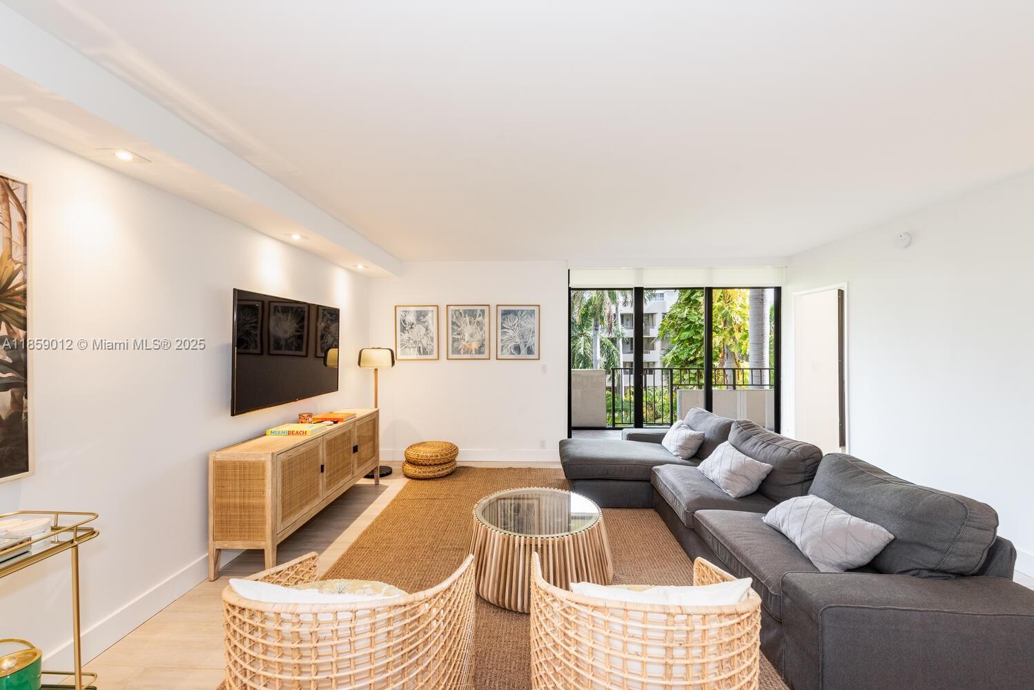 181 Crandon Boulevard, Unit 306 Key Biscayne, FL 33149 - Photo 4 of 25 a living room with furniture a flat screen tv and a window