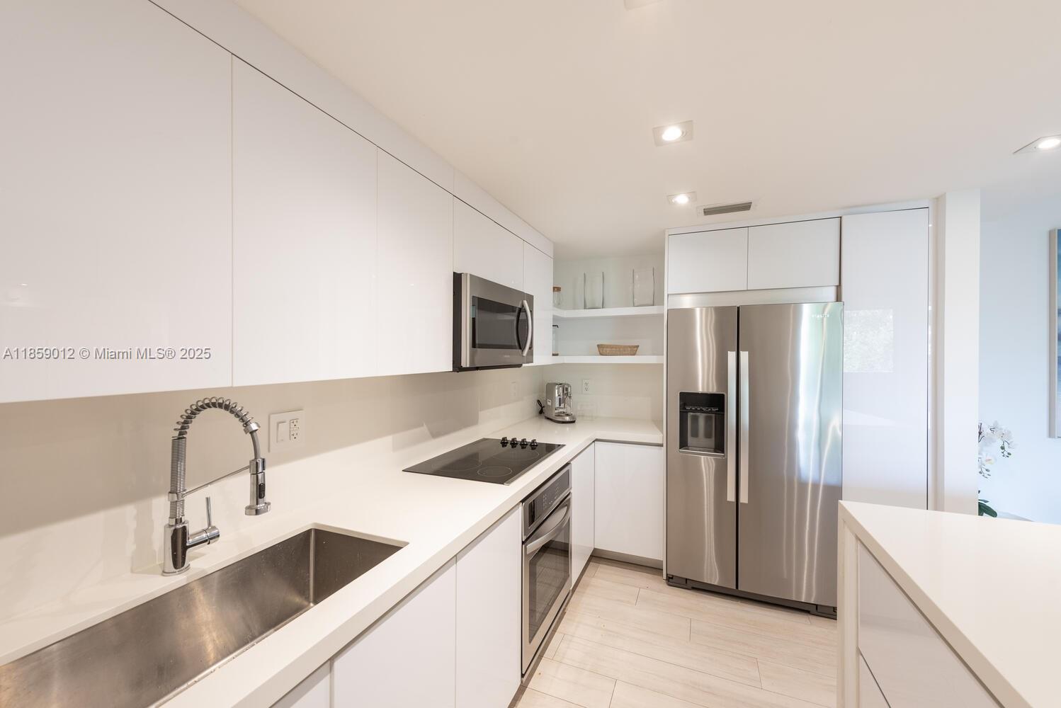 181 Crandon Boulevard, Unit 306 Key Biscayne, FL 33149 - Photo 7 of 25 a kitchen with stainless steel appliances granite countertop a sink stove and refrigerator