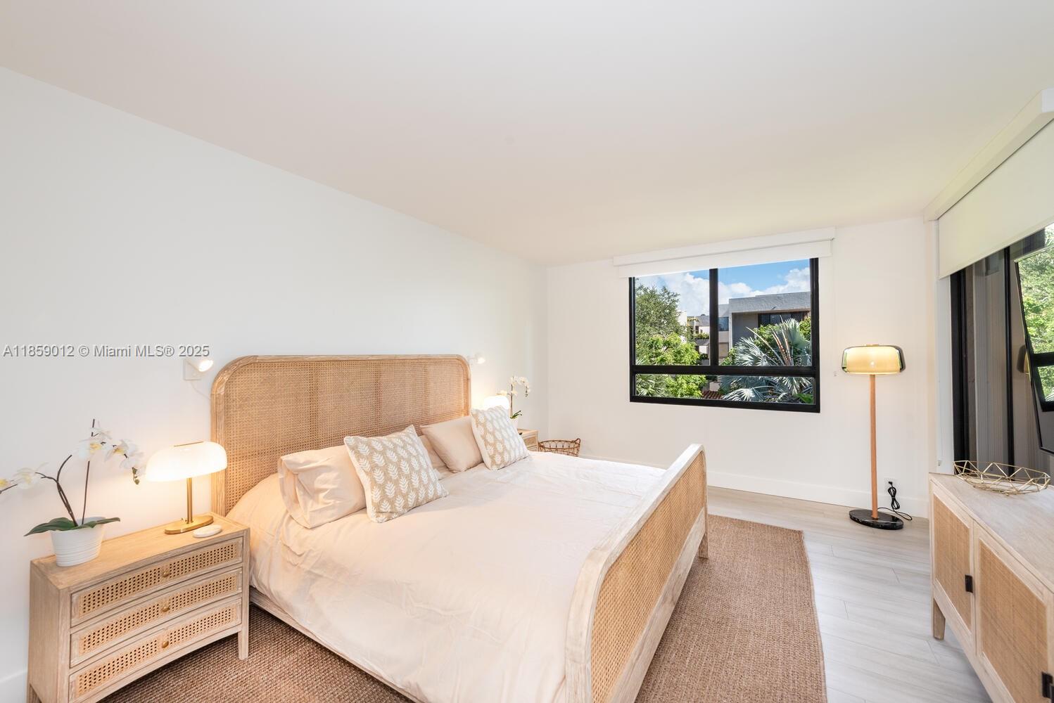 181 Crandon Boulevard, Unit 306 Key Biscayne, FL 33149 - Photo 10 of 25 a bedroom with a bed and a flat screen tv