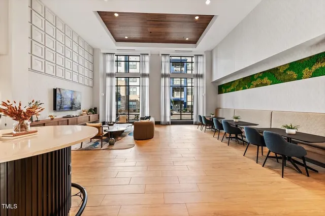 a living room with furniture a flat screen tv and a large window