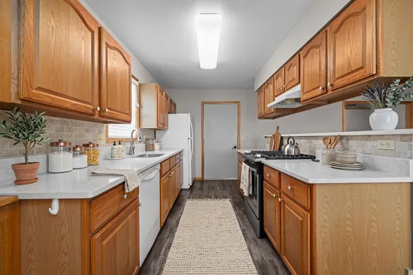 a kitchen with stainless steel appliances granite countertop a sink stove and cabinets