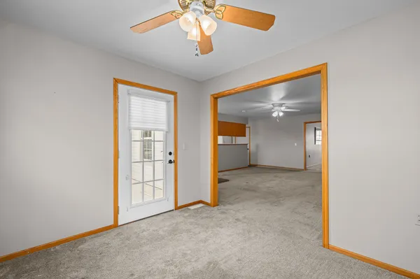 an empty room with closet and a chandelier fan