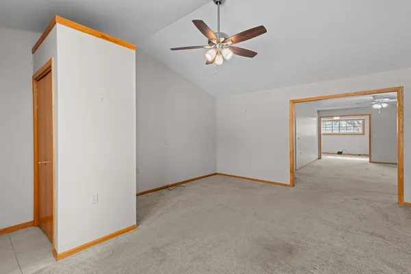 an empty room with closet and a chandelier fan