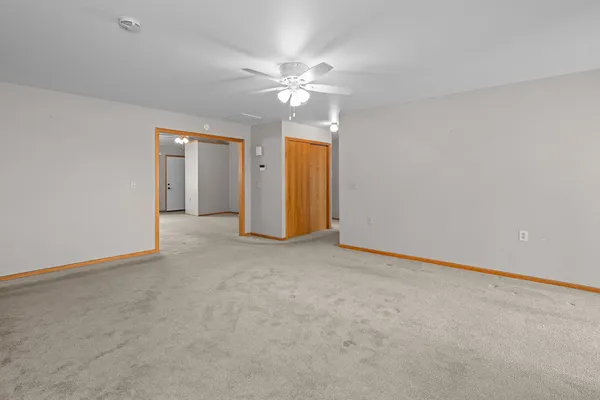 an empty room with closet and a ceiling fan