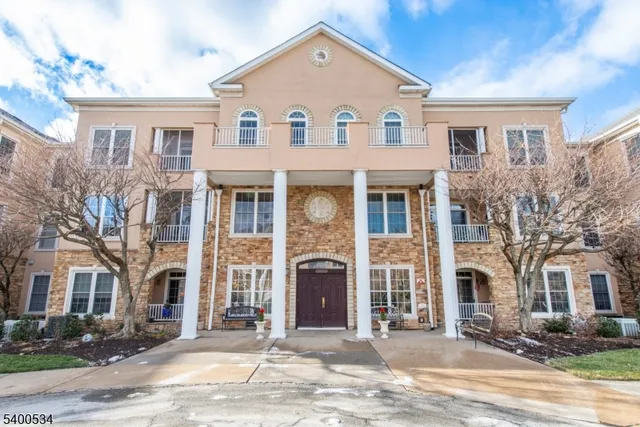 a front view of a house with yard and parking