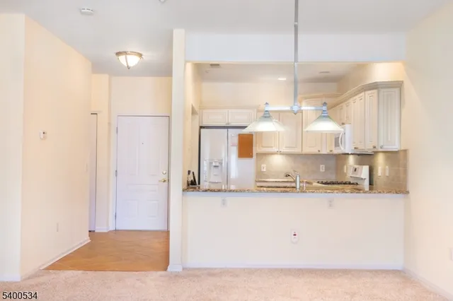 a kitchen with kitchen island a counter top space a sink stainless steel appliances and cabinets