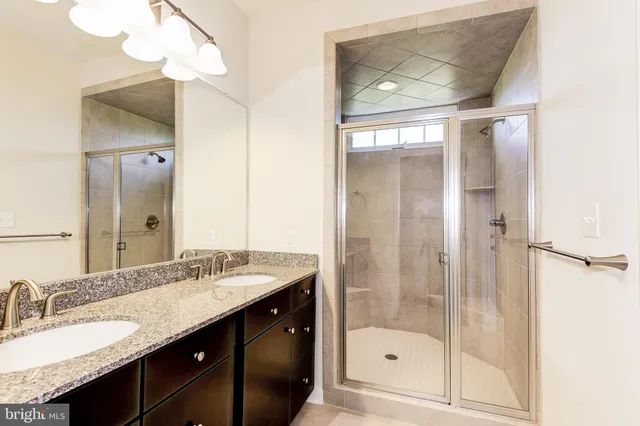 a bathroom with a shower sink vanity and mirror