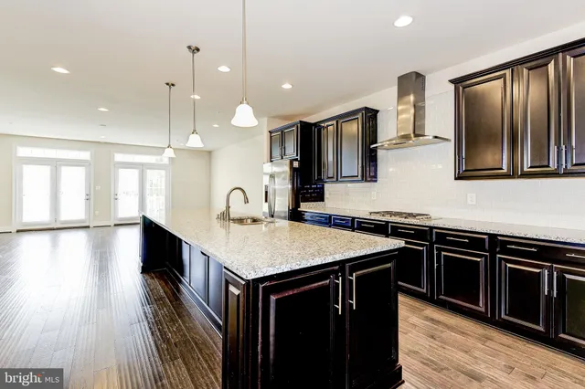 a kitchen with a sink stove and wooden floor