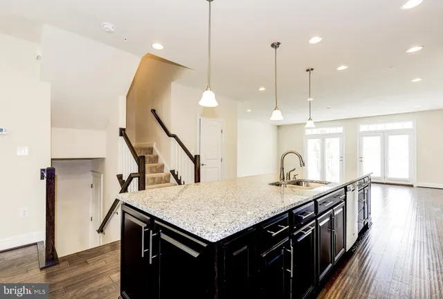 a kitchen with a kitchen island a stove and a wooden floor