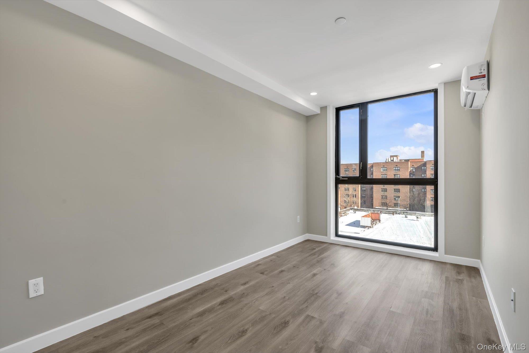 55-40 97th Place Queens, NY 11368 - Photo 6 of 11 an empty room with wooden floor and a window