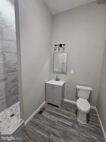 a bathroom with a toilet a sink and mirror