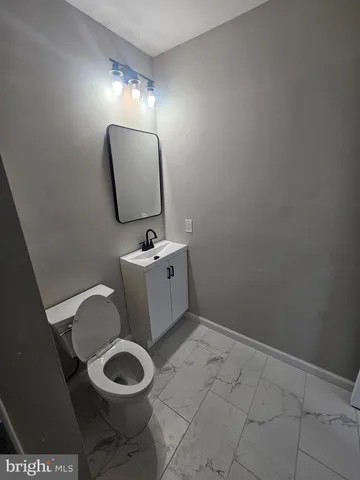 a bathroom with a toilet mirror and vanity