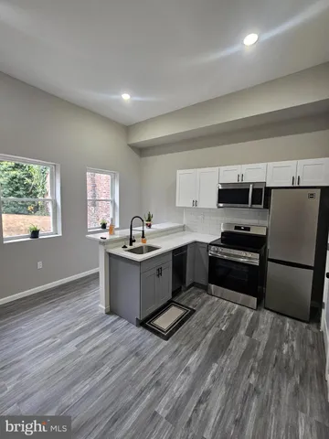 a kitchen with a refrigerator and a stove top oven