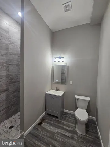 a bathroom with a toilet a sink and mirror