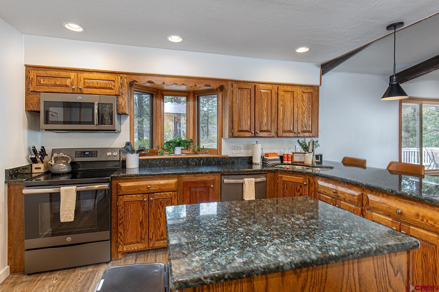 19 Newland Circle Durango, CO 81301 - Photo 12 of 44 a kitchen with stainless steel appliances granite countertop a stove a sink and a microwave