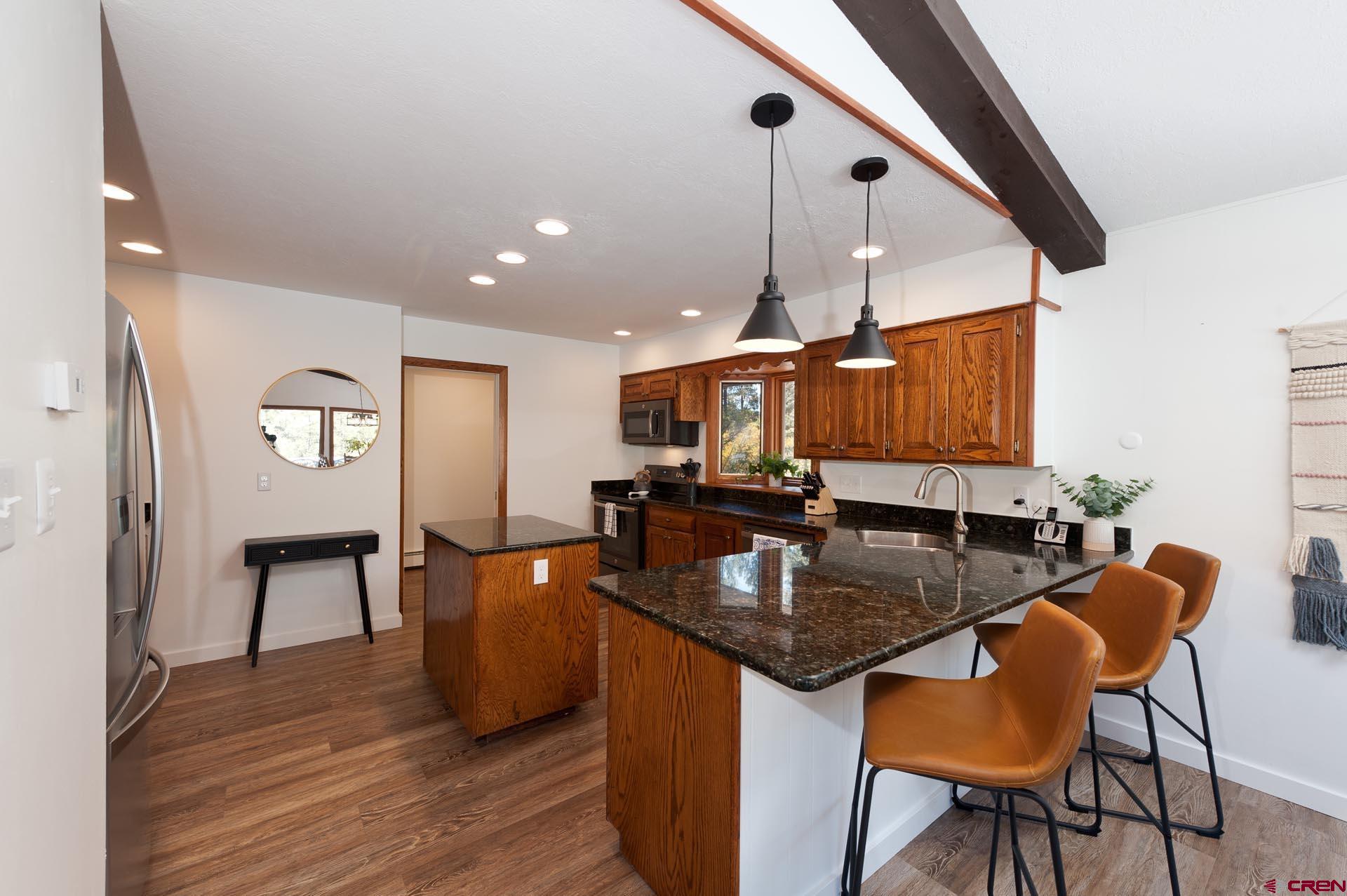 19 Newland Circle Durango, CO 81301 - Photo 14 of 44 a kitchen with stainless steel appliances granite countertop a sink counter space and wooden floor