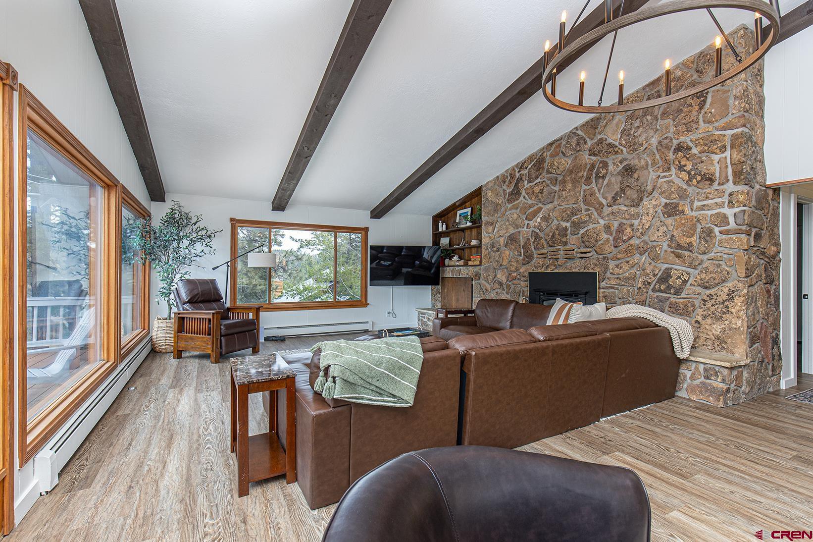 19 Newland Circle Durango, CO 81301 - Photo 6 of 44 a living room with furniture a fireplace and a floor to ceiling window