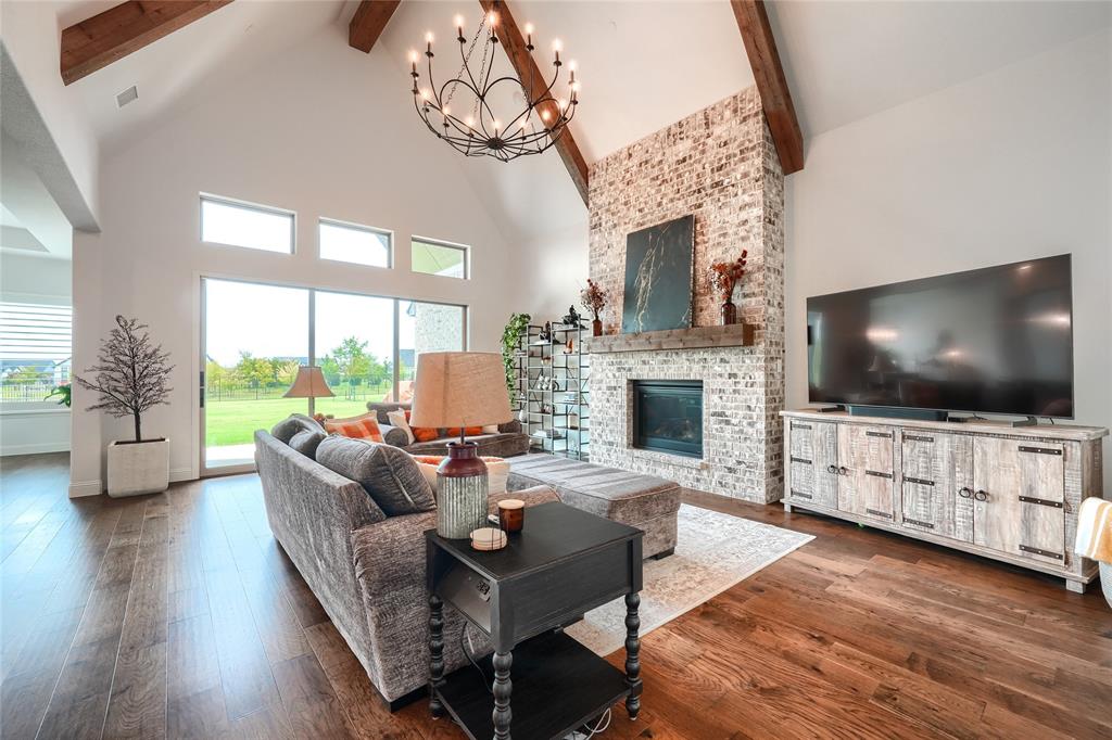 462 Infinito Drive Sunnyvale, TX 75182 - Photo 9 of 37 Living room with hanging lights, dark wood-style flooring, a fireplace, and healthy amount of natural light