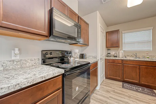 a kitchen with stainless steel appliances granite countertop a sink stove and microwave