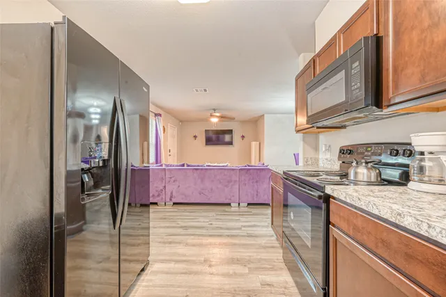 a kitchen with stainless steel appliances granite countertop a sink refrigerator and cabinets