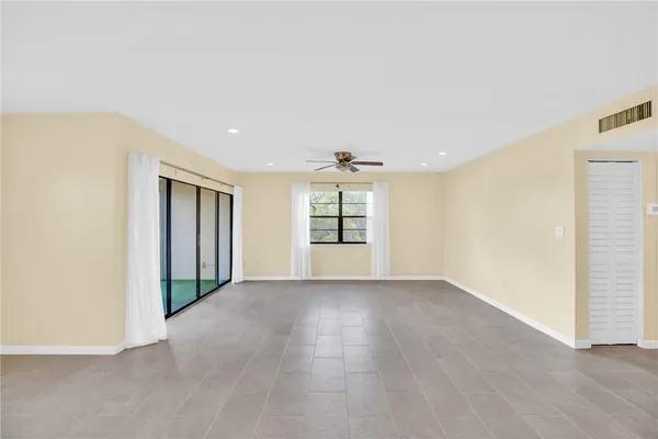 an empty room with windows and cabinet