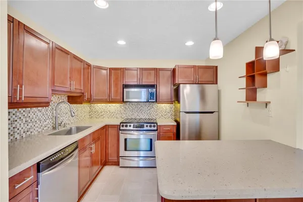a kitchen with stainless steel appliances granite countertop a sink stove and refrigerator