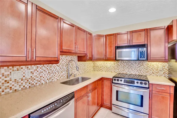 a kitchen with granite countertop a sink stove and cabinets