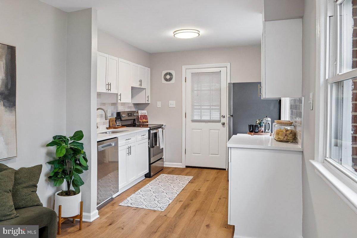 3921 Lantern Drive Silver Spring, MD 20902 - Photo 7 of 46 a kitchen with a refrigerator and a white cabinets