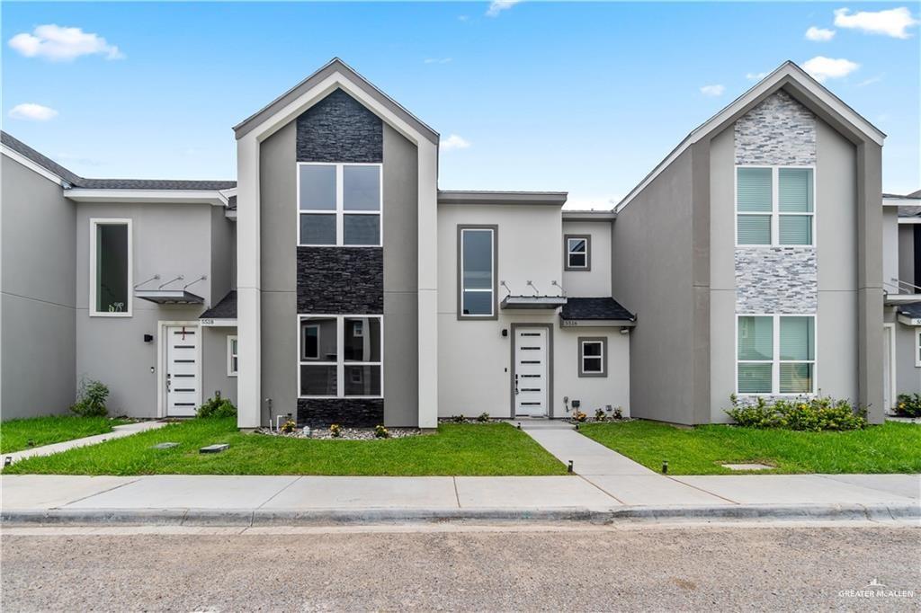 a front view of a house with a garden and plants