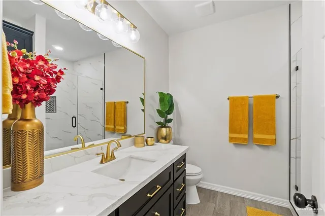 a bathroom with a granite countertop sink a mirror and a shower