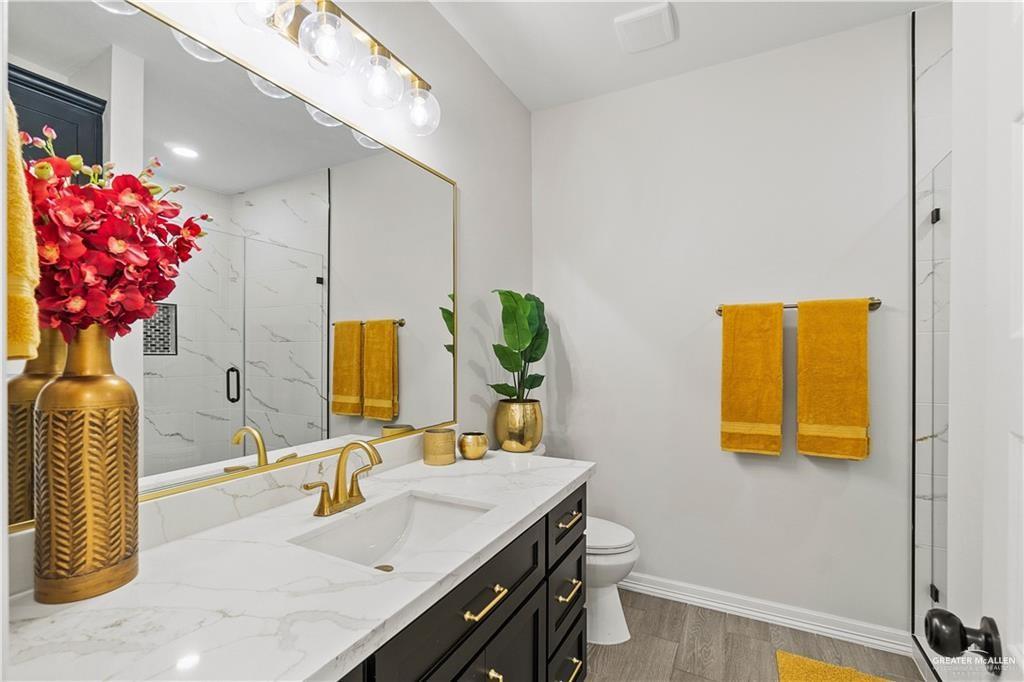 5516 North Crown Point Pharr, TX 78577 - Photo 19 of 27 a bathroom with a granite countertop sink a mirror and a shower