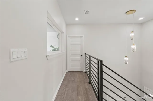 a view of a hallway with wooden floor and staircase