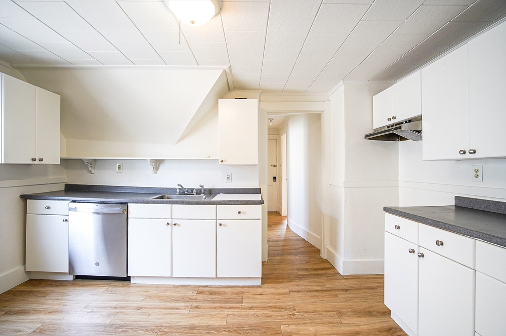 83-85 Wilmont Street, Unit 3 Springfield, MA 01108 - Photo 3 of 12 a kitchen with stainless steel appliances granite countertop a sink and stove top oven