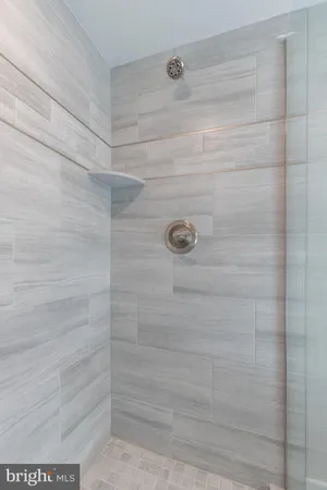 a bathroom with a sink a toilet a mirror and shower