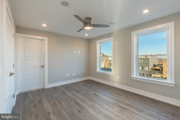 an empty room with wooden floor and windows