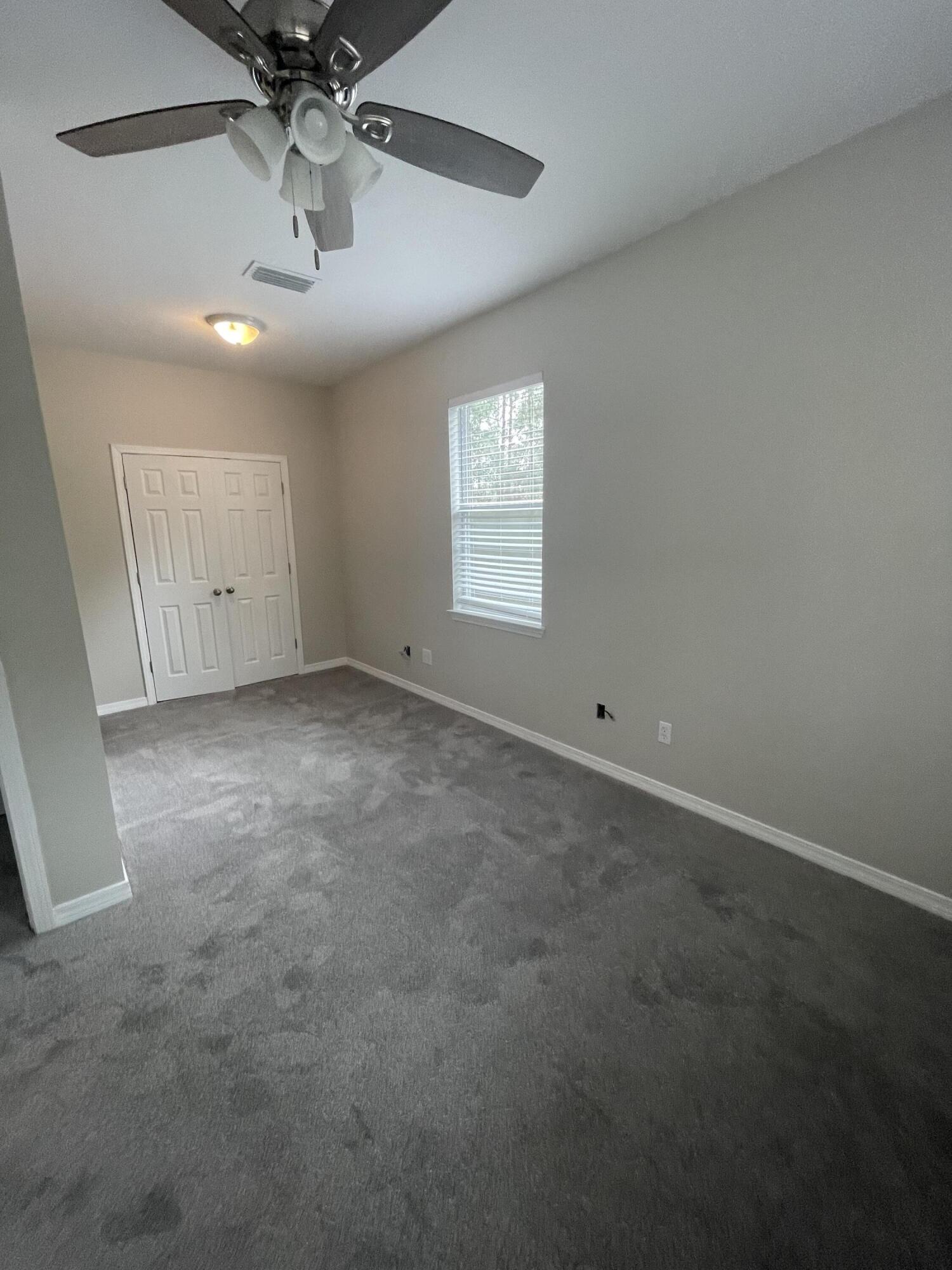 47 15th Street Santa Rosa Beach, FL 32459 - Photo 12 of 20 an empty room with a chandelier fan and windows