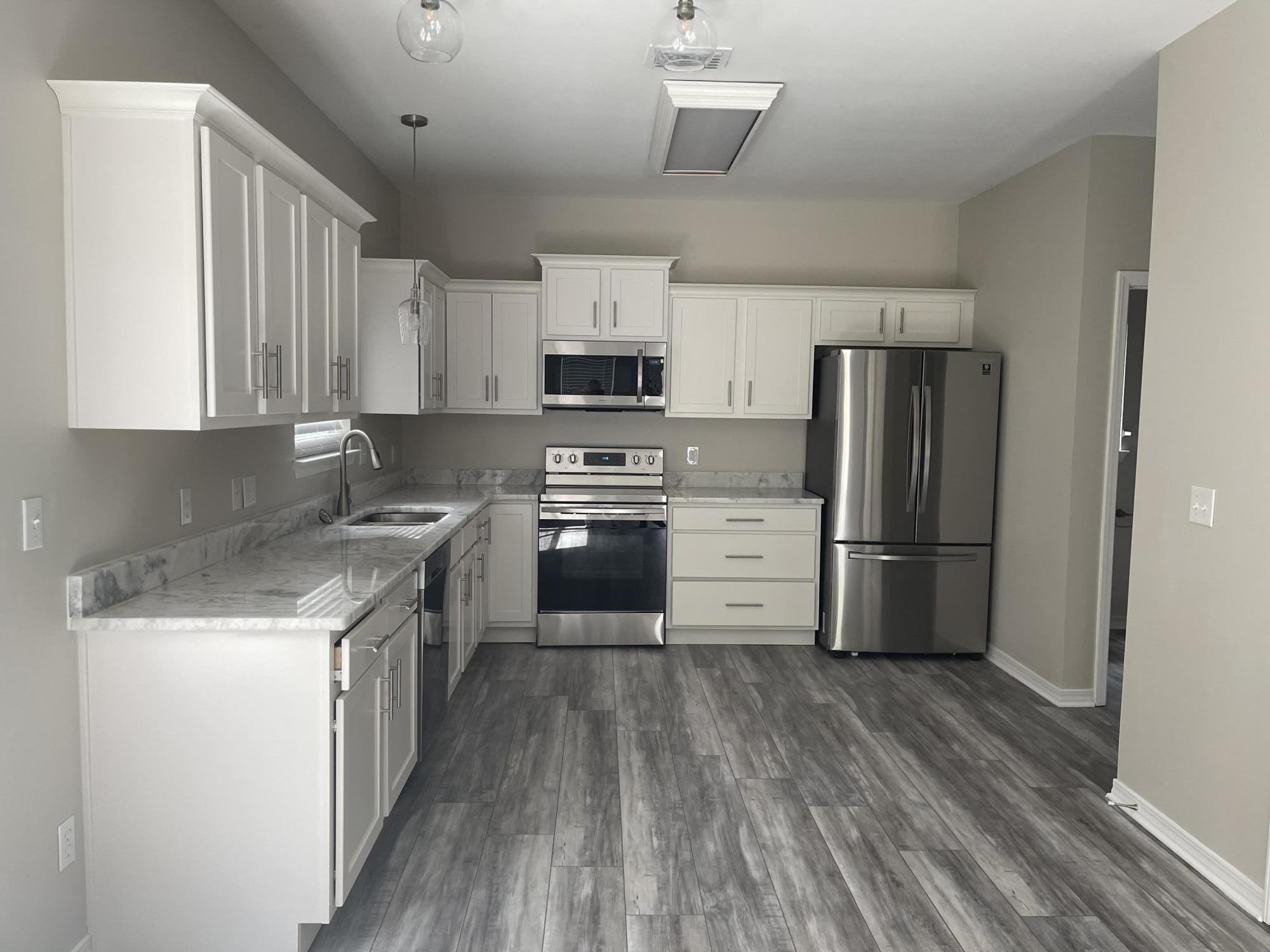 47 15th Street Santa Rosa Beach, FL 32459 - Photo 3 of 20 a kitchen with a refrigerator a stove top oven a sink and dishwasher with wooden floor