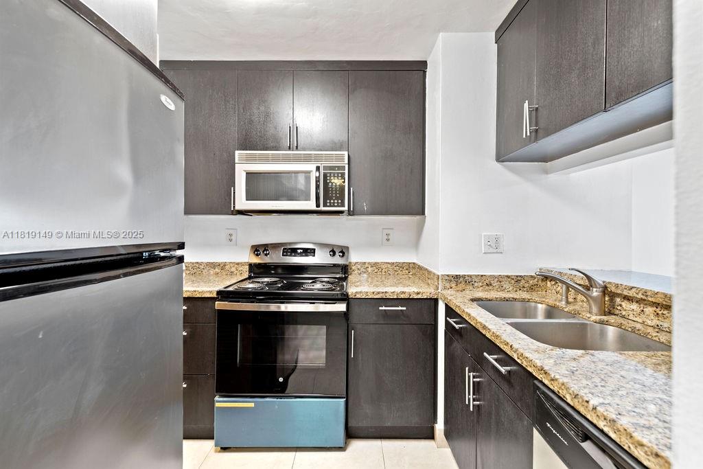 850 North Miami Avenue, Unit W1001 Miami, FL 33136 - Photo 3 of 30 a kitchen with granite countertop a sink stove and microwave