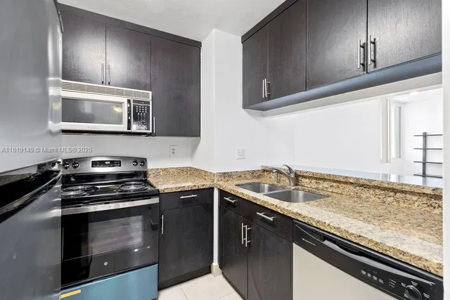 a kitchen with granite countertop a stove sink and cabinets