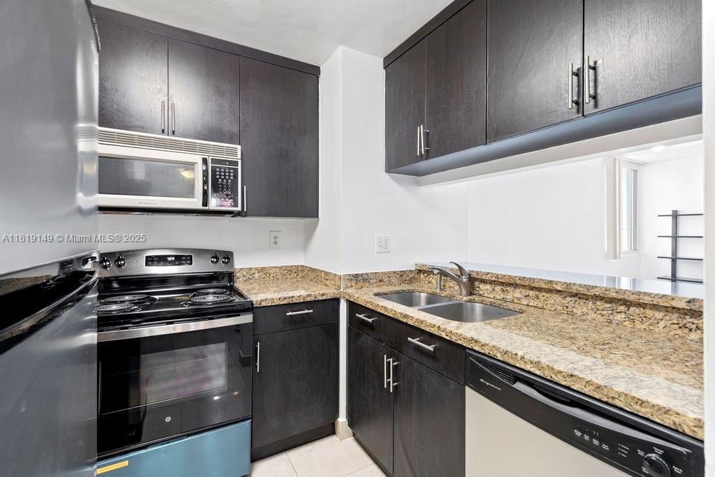 850 North Miami Avenue, Unit W1001 Miami, FL 33136 - Photo 4 of 30 a kitchen with granite countertop a stove sink and cabinets