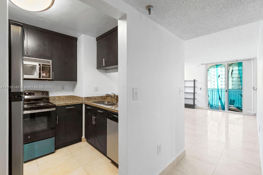 850 North Miami Avenue, Unit W1001 Miami, FL 33136 - Photo 5 of 30 a kitchen with stainless steel appliances granite countertop a stove a sink and a microwave