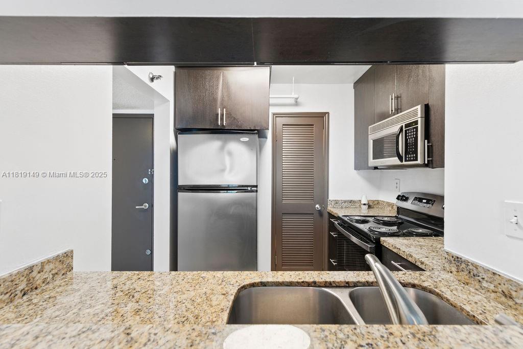 850 North Miami Avenue, Unit W1001 Miami, FL 33136 - Photo 6 of 30 a kitchen with a sink a refrigerator and a stove top oven