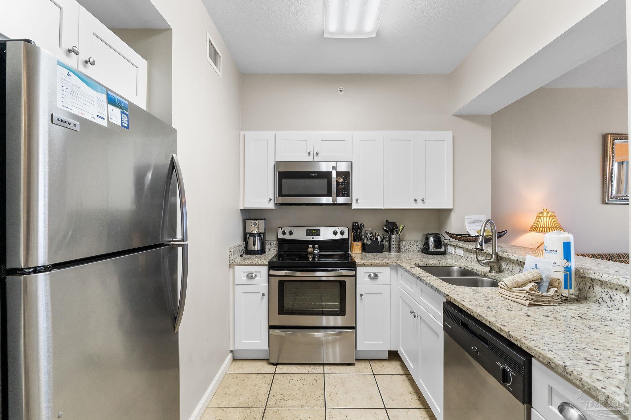 14511 Perdido Key Drive, Unit 904 Perdido Key, FL 32507 - Photo 16 of 64 a kitchen with a sink a refrigerator and a stove top oven